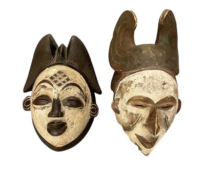 Lot 1059 - Two African carved wooden and white painted...