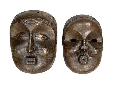 Lot 1093 - Two African carved wooden masks, the larger...