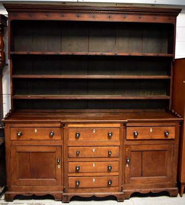 Lot 104 - A George III oak dresser with an enclosed...
