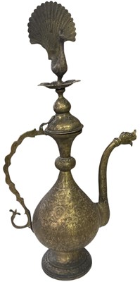 Lot 1216 - An Indian brass ewer, surmounted with peacock...