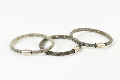 Lot 792 - Three white metal bangles with magnetic clasps...