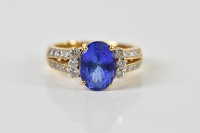 Lot 1394 - An 18ct yellow gold tanzanite and diamond ring,...