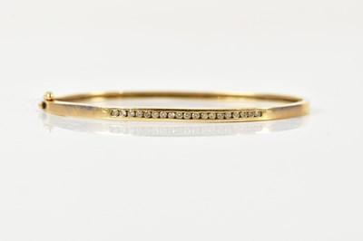 Lot 1554 - A 9ct yellow gold oval hinged snap bangle,...