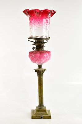 Lot 1293 - A Victorian brass oil lamp, the cranberry and...