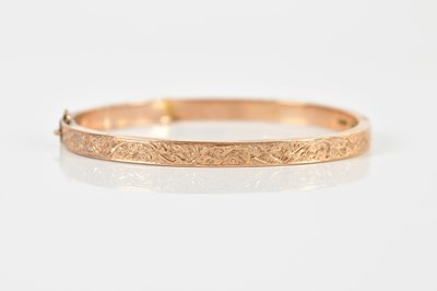 Lot 1574 - A 9ct yellow gold oval hinged snap bangle with...
