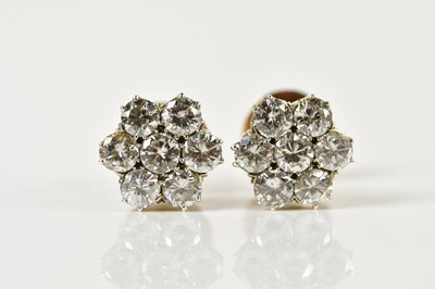 Lot 1665 - A pair of diamond flower head ear studs, each...