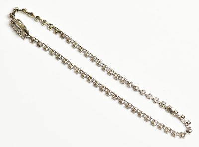 Lot 1557 - A white metal and diamond line bracelet,...