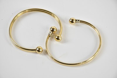Lot 1570 - Two 9ct yellow gold torque bangles, combined...
