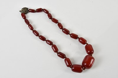 Lot 1637 - A graduated string of cherry amber beads,...