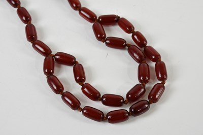 Lot 1634 - A cherry amber bead necklace formed of equal...
