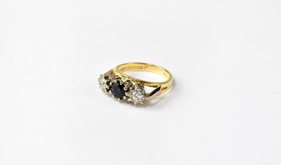 Lot 1019 - An 18ct gold ring set with central blue stone...