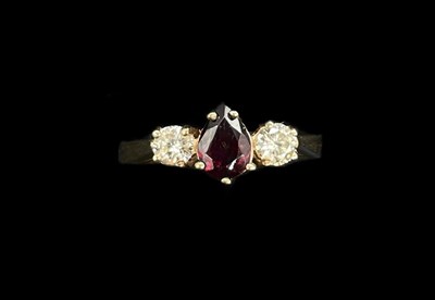 Lot 1184 - A 9ct yellow gold three stone ruby and diamond...