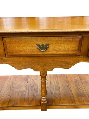 Lot 35 - A reproduction oak three drawer dresser base,...