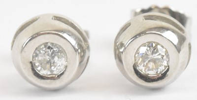 Lot 1402 - A pair of 18ct white gold and diamond ear...