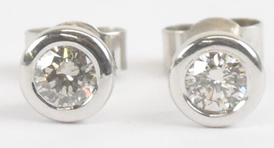 Lot 1403 - A pair of 18ct white gold diamond ear studs,...
