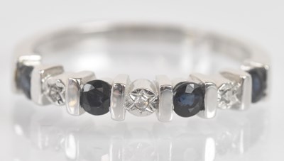 Lot 1318 - A 9ct white gold sapphire and diamond chip...