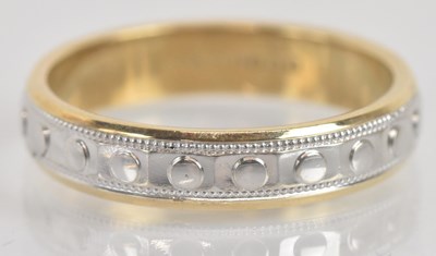 Lot 1323 - A 9ct yellow and white gold wedding band, with...