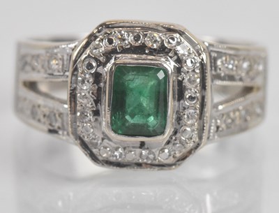 Lot 1288 - An 18ct white gold emerald and diamond dress...