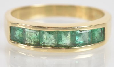 Lot 1326 - A 14ct yellow gold emerald set half eternity...