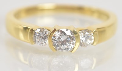Lot 1279 - An 18ct yellow gold three stone diamond ring,...