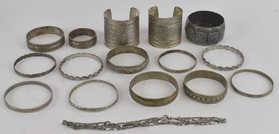 Lot 1491 - Sixteen white metal bangles and a flat Cuban...
