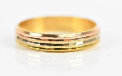 Lot 169 - A yellow metal wedding band with textured...