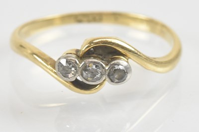Lot 1295 - An 18ct gold three stone diamond ring, the...