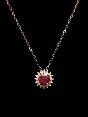 Lot 1296 - A 9ct yellow gold ruby and diamond halo set...