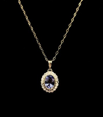Lot 1300 - A 9ct yellow gold oval tanzanite and diamond...