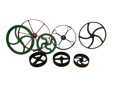 Lot 1311 - A group of eight cast metal wheels and turning...