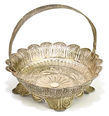Lot 2157 - A white metal filigree swing handled basket on...