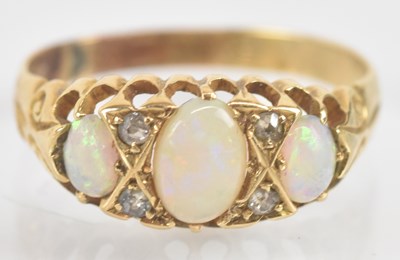 Lot 1298 - An 18ct gold three stone opal ring, size N,...