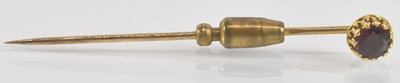 Lot 1293 - A yellow metal tie pin with claw set garnet,...