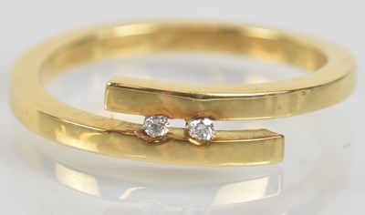 Lot 1256 - An 18ct yellow gold two stone diamond set ring,...