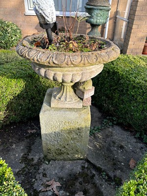 Lot 150 - A reconstituted stone urn on square form...