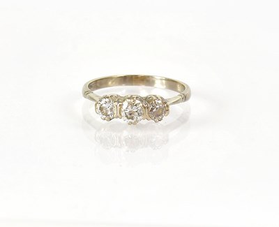 Lot 834 - A white metal three-stone diamond ring in a...