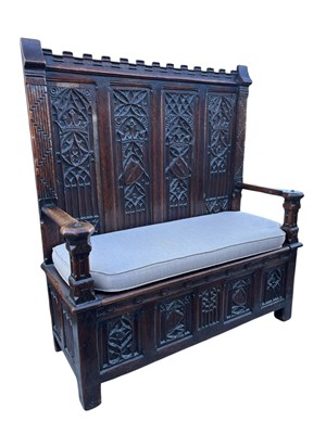 Lot 1112 - A Gothic Revival carved oak settle, with...
