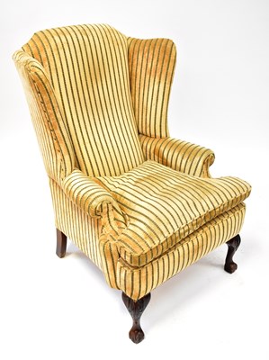 Lot 51 - An early 20th century wing back armchair with...
