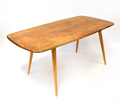 Lot 4 - ERCOL; a blonde elm rounded rectangular dining...