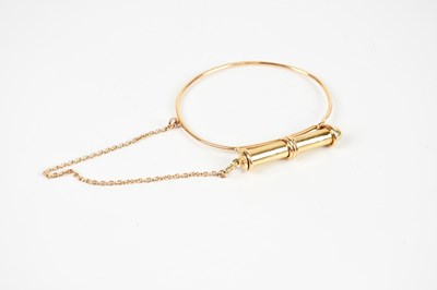 Lot 250 - A yellow metal bangle, with attached yellow...