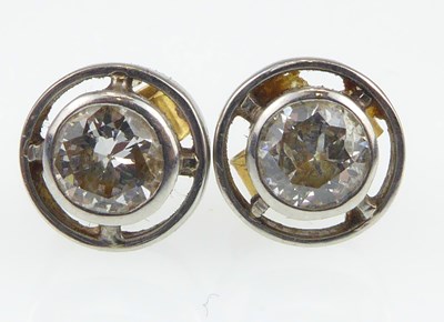 Lot 1192 - A pair of diamond stud earrings, each collet...