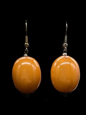 Lot 1287 - A pair of egg yolk/butterscotch amber coloured...