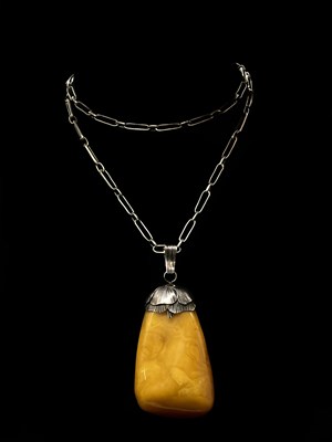 Lot 1289 - A large amber coloured pendant with organic...