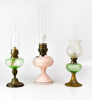 Lot 162 - Three oil lamps, two with green glass...