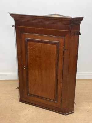 Lot 658 - An oak corner cabinet with three shelves,...