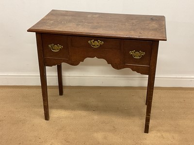 Lot 649 - An oak lowboy with three drawers and shaped...