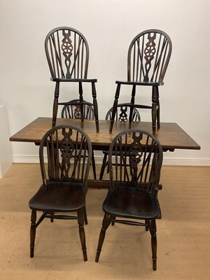 Lot 675 - A set of six stained pine wheel back dining...
