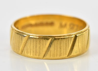 Lot 105 - A broad 22ct yellow gold wedding band, further...