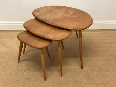 Lot 588 - ERCOL; a nest of three pebble tables in elm...