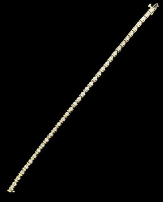 Lot 1126 - A 10ct yellow gold diamond tennis bracelet,...